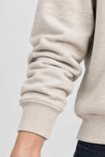 Close-up of long sleeve and ribbed cuff on women’s oatmeal beige sweatshirt